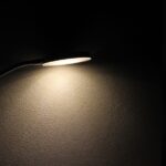 black background desk lamp casts arc of light